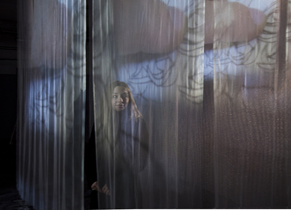 Immagine di una bambine dietro una tenda